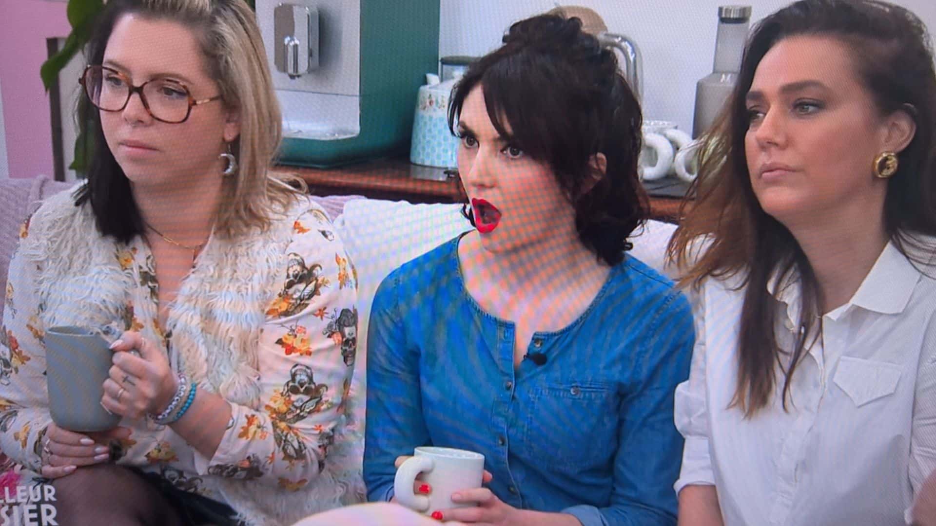 Trois femmes assises avec des tasses, discutant.