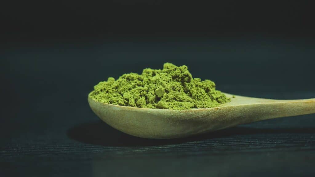 Cuillère en bois avec poudre verte.