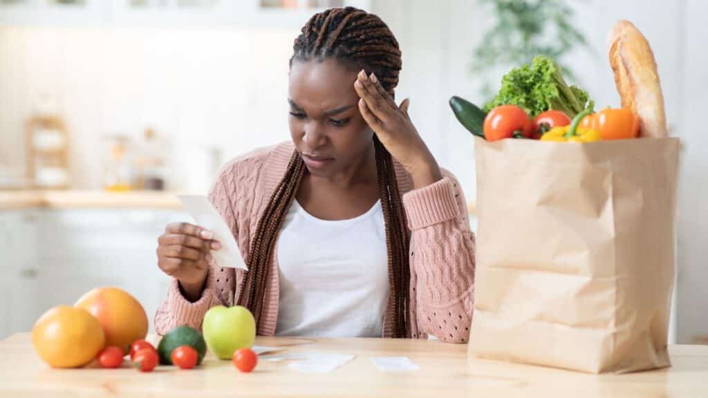 Personne vérifiant un reçu près de courses alimentaires.