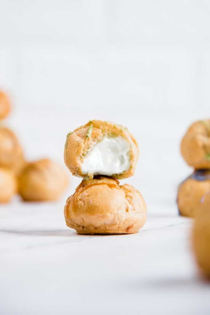 Choux à la crème empilés, sur fond blanc.