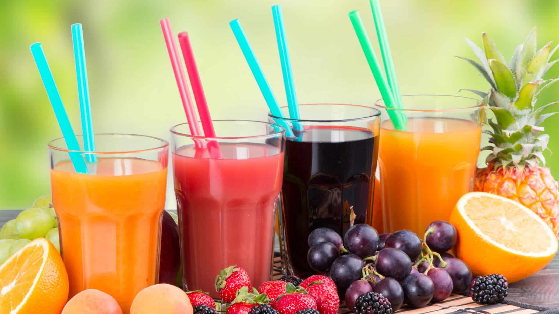 Jus de fruits variés avec pailles colorées.