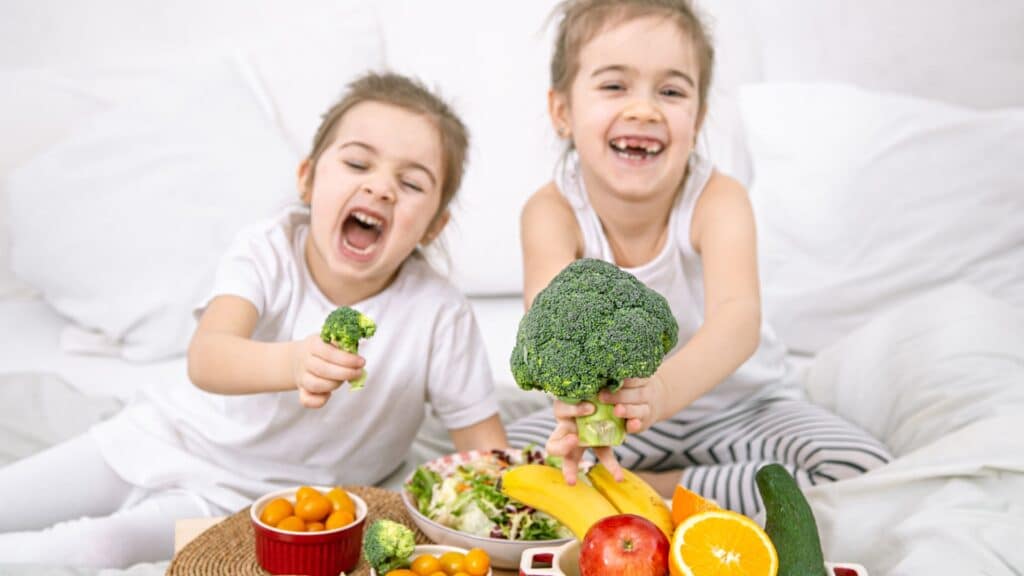 Enfants souriants avec des légumes et fruits