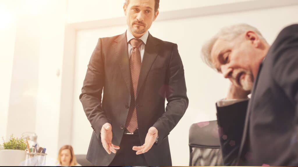 Discussion entre deux hommes en costume au bureau.