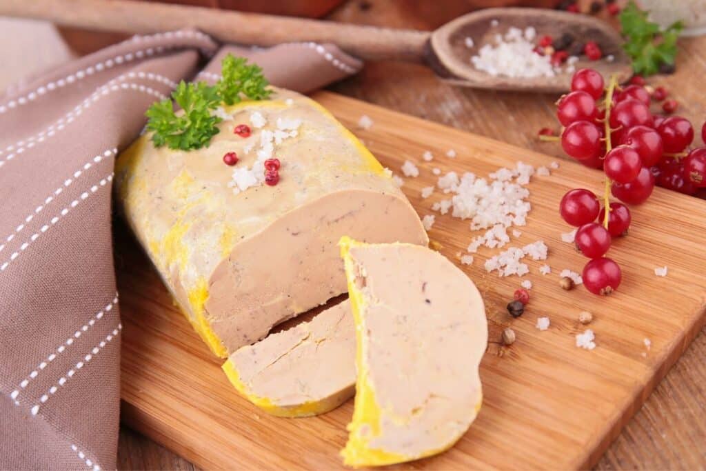 Foie gras sur planche en bois avec groseilles.