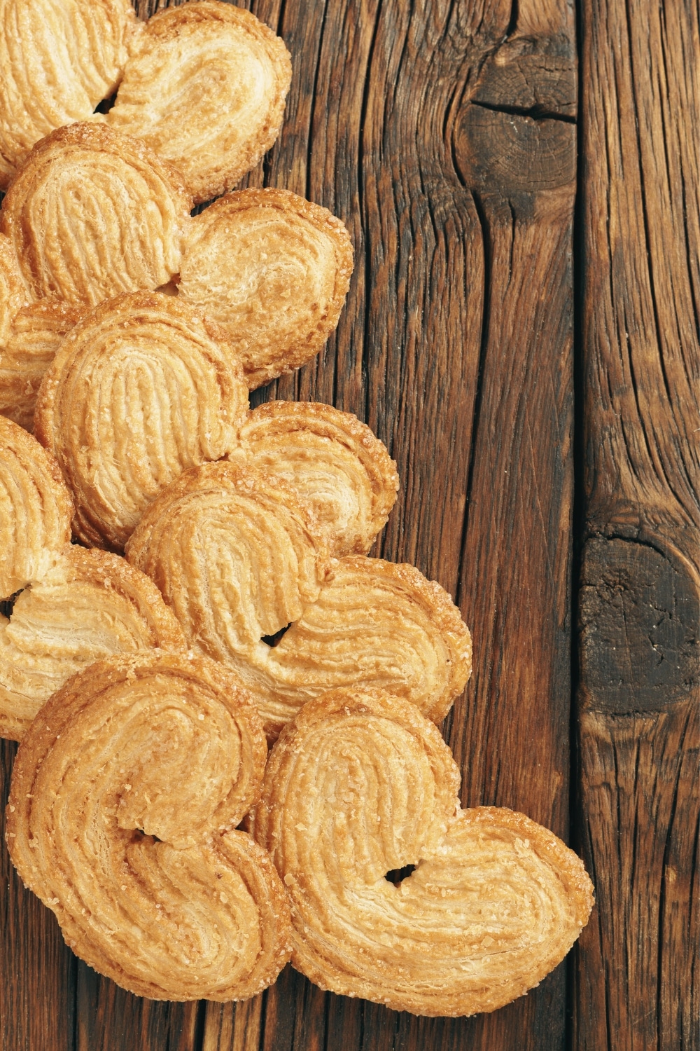 Palmiers feuilletés sur table en bois rustique.