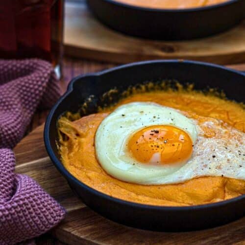 Oeuf au plat sur purée dans poêle.