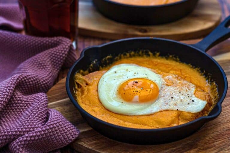 Oeuf au plat sur purée dans poêle.
