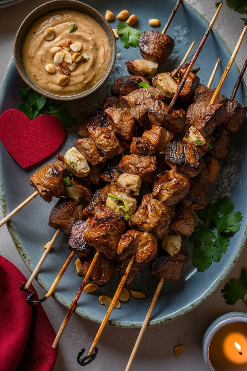 Brochettes de viande servies avec sauce aux cacahuètes.