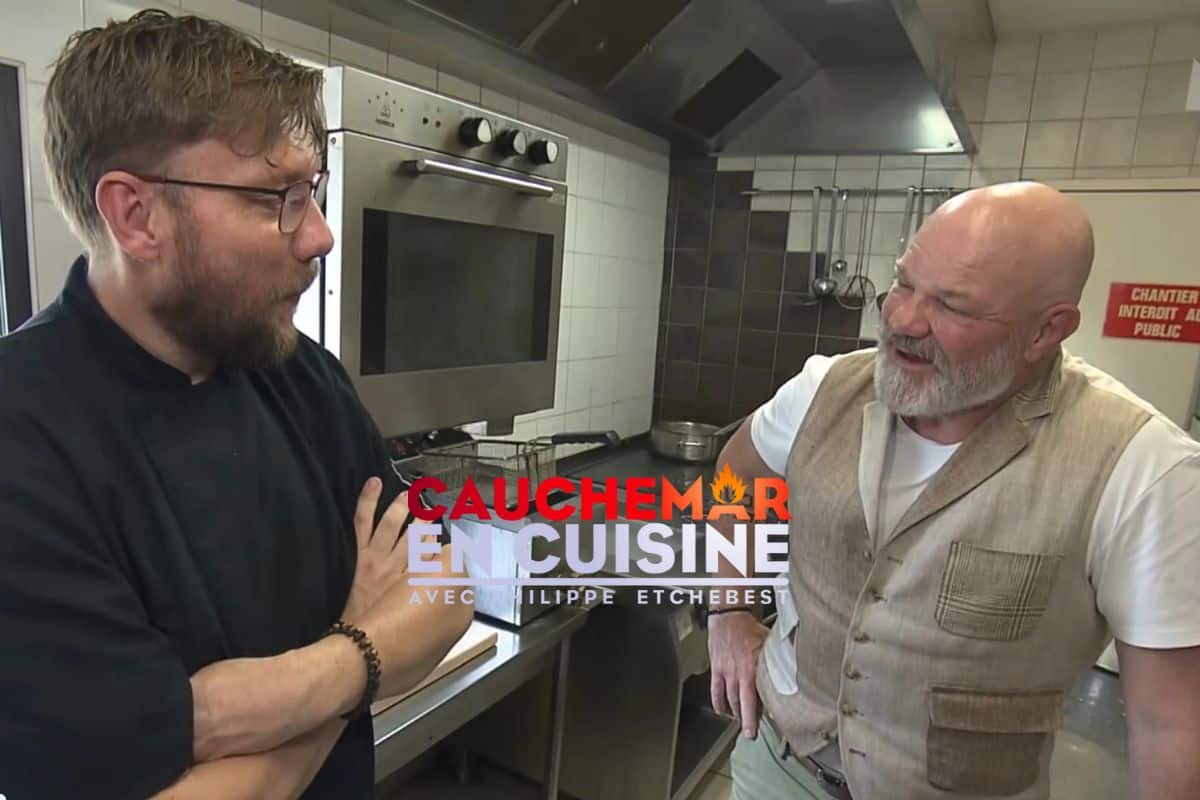 Deux chefs discutent dans une cuisine professionnelle.