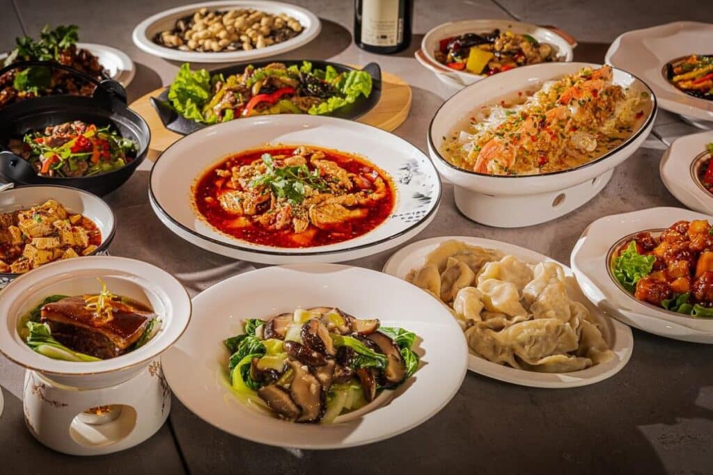 Assortiment de plats chinois variés sur une table.