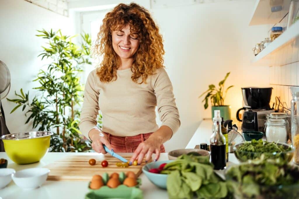 Femme préparant des légumes dans la cuisine