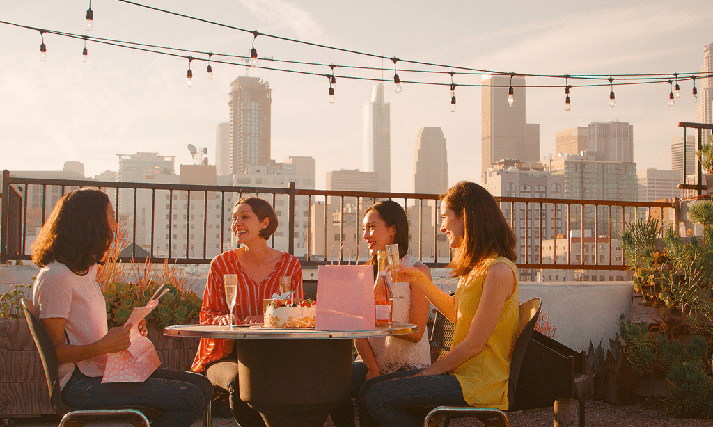 Amis discutant sur une terrasse en ville.