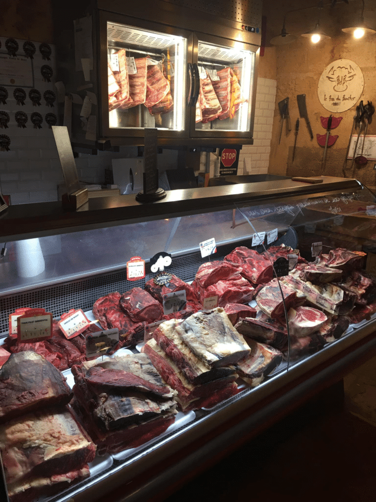 Vitrine de boucherie avec morceaux de viande exposés.
Le Bar du Boucher