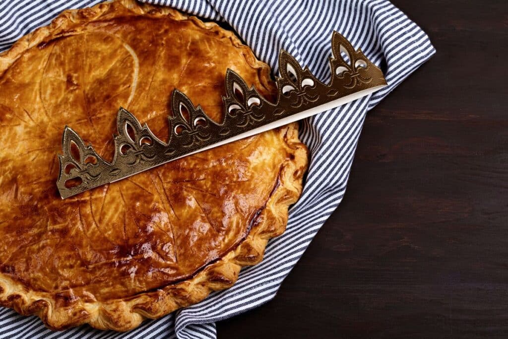 Galette des rois sur nappe rayée, couronne dessus.