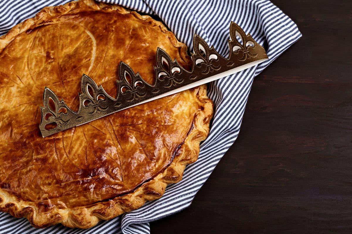 Galette des rois sur nappe rayée, couronne dessus.