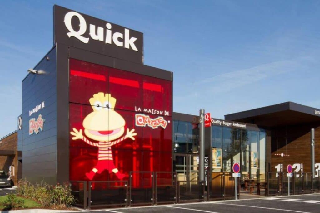 Restaurant Quick moderne avec personnage jaune sur façade.