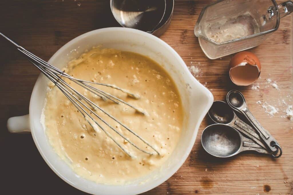 Pâte à gâteau avec ustensiles de cuisine sur table.