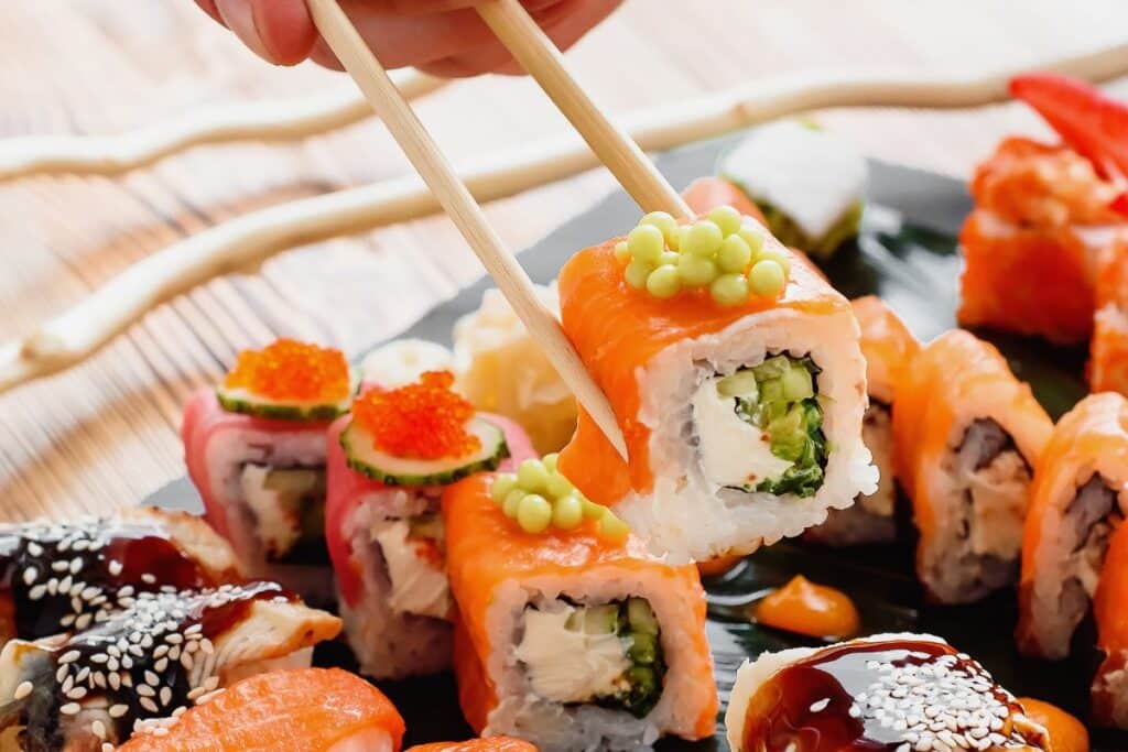 Assortiment de sushis colorés avec des baguettes.