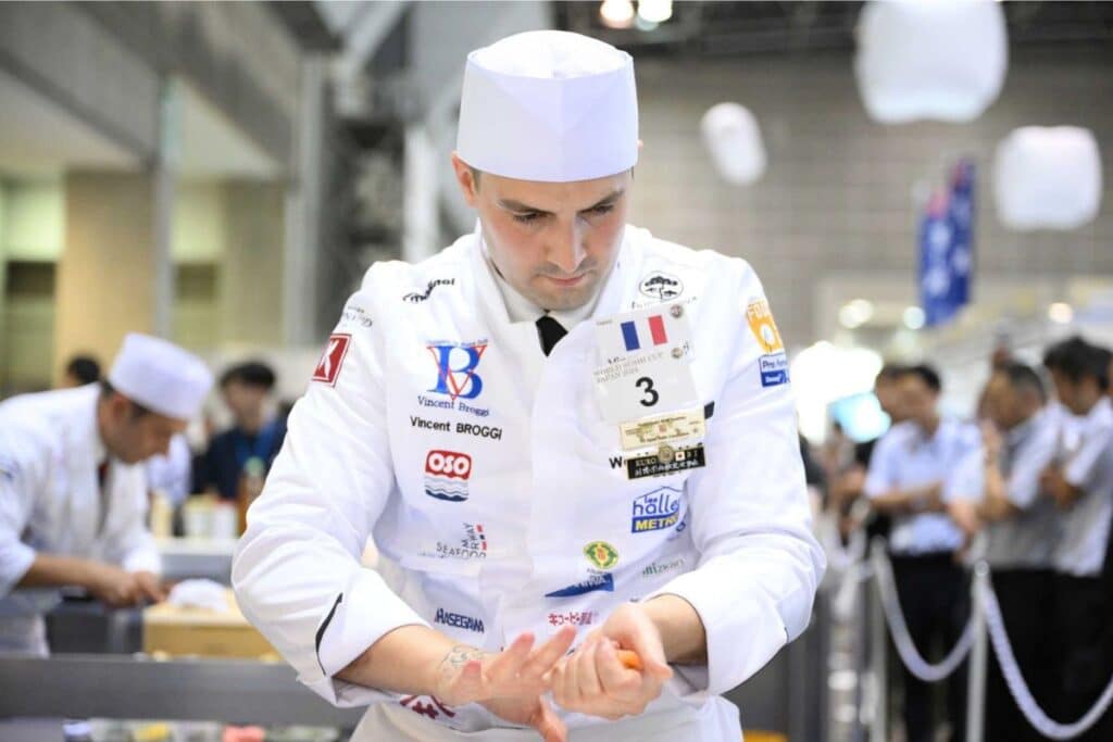 Chef préparant un plat en compétition culinaire.
