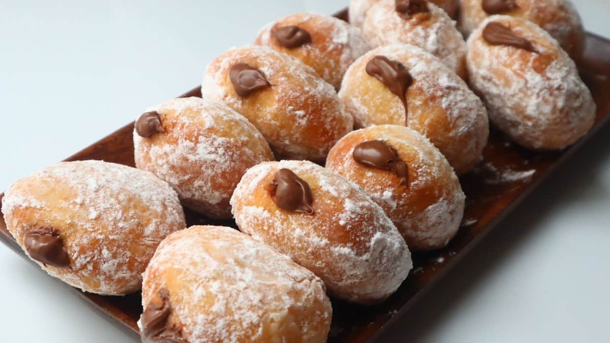 Beignets au chocolat sur un plateau en bois.