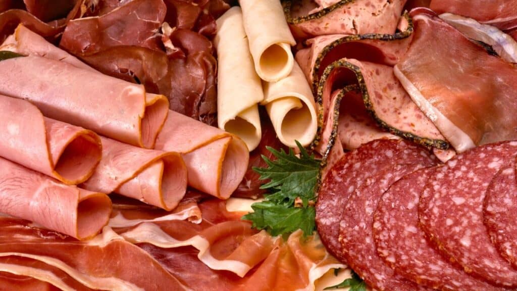 Plateau de charcuterie variée avec herbes.