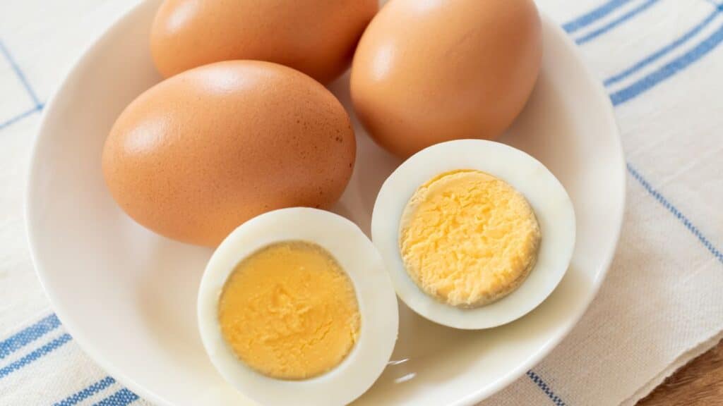 Oeufs entiers et durs sur une assiette blanche.