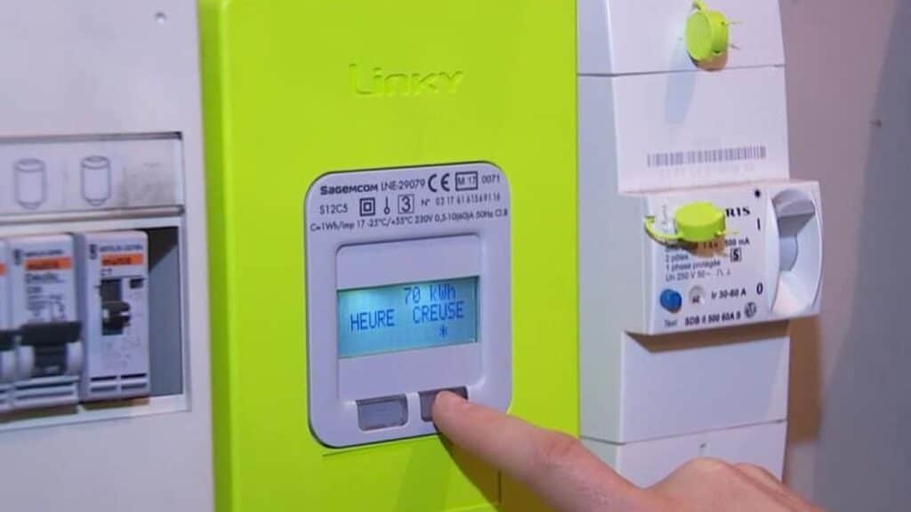 Doigt appuyant sur compteur électrique Linky.