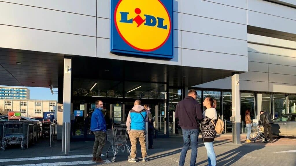 Entrée d'un supermarché avec clients.