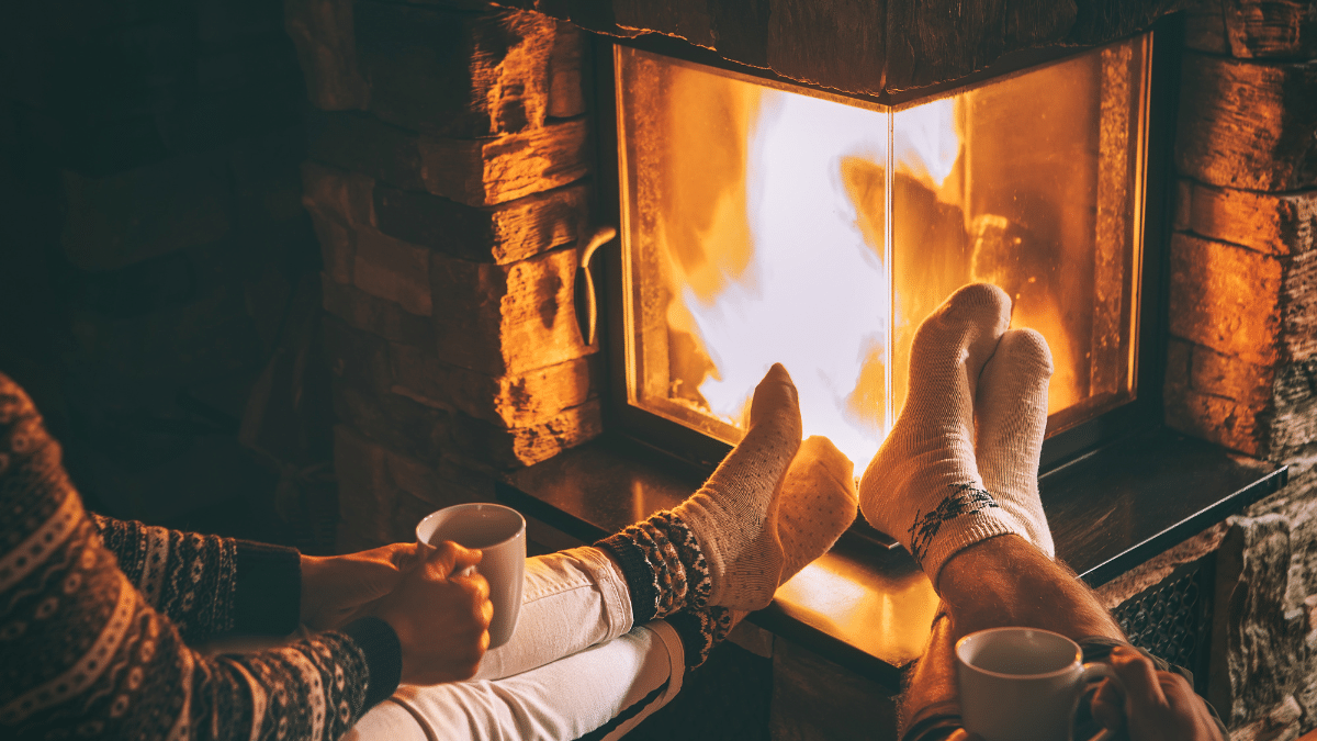 Pieds devant cheminée, ambiance cosy et hivernale.