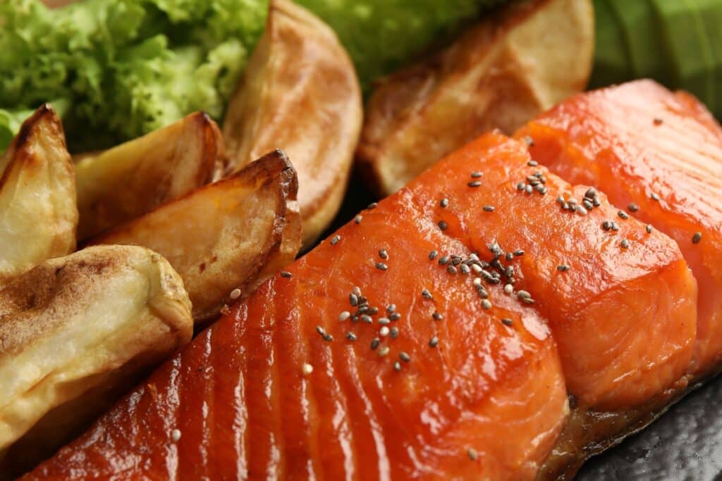 Saumon avec pommes de terre et salade verte.