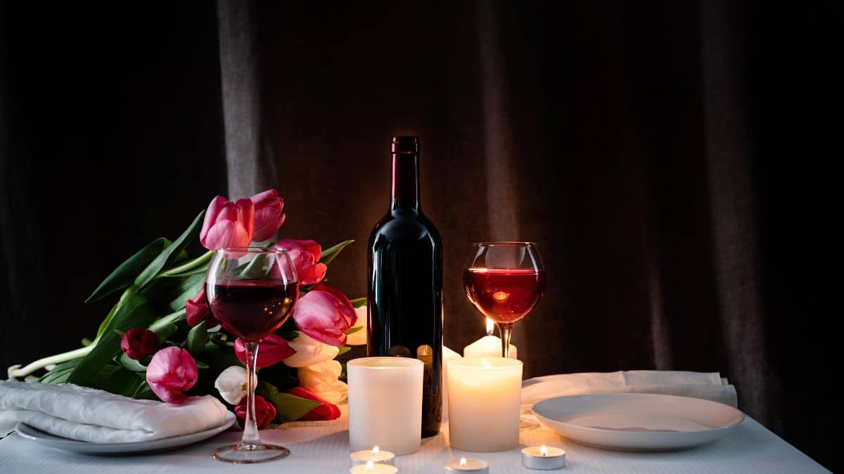 Dîner romantique avec vin, tulipes et bougies.