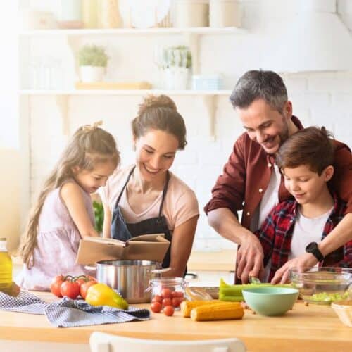 Famille cuisine ensemble dans une cuisine lumineuse.