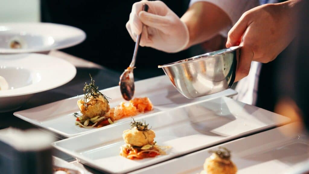 Chef préparant des assiettes gastronomiques en cuisine.