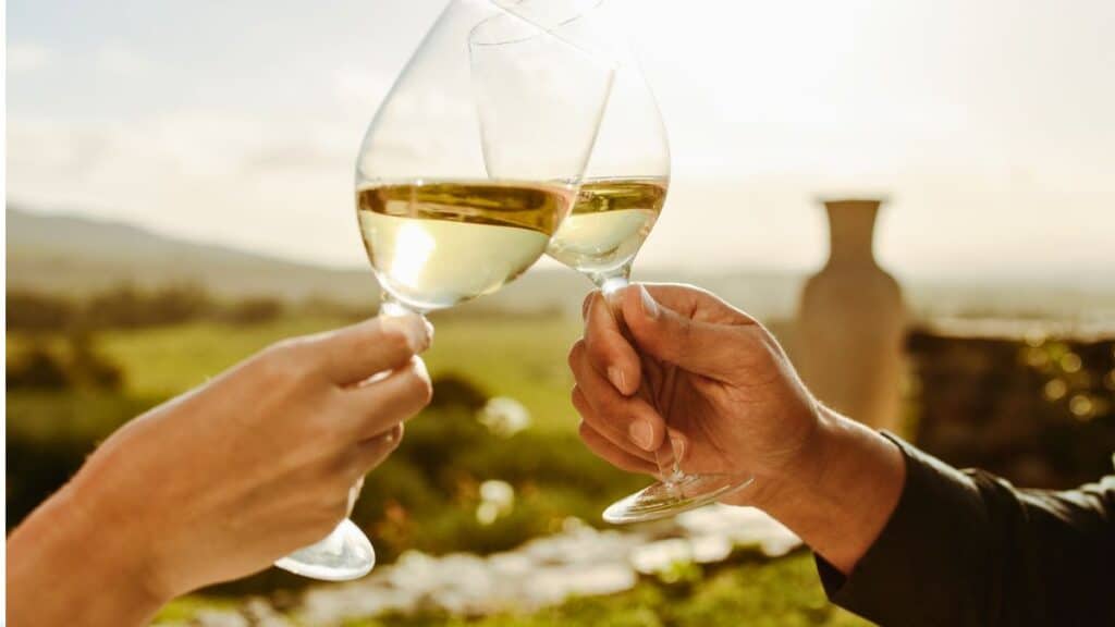 Trinquer avec des verres de vin blanc.