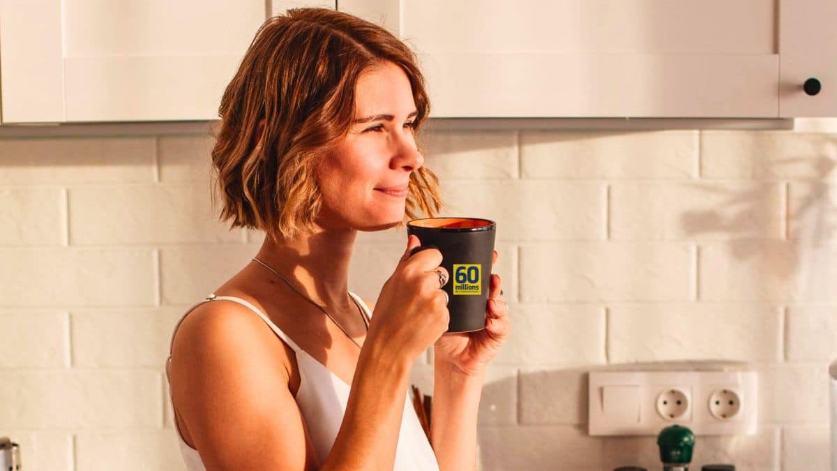 Femme buvant du café dans une tasse noire.