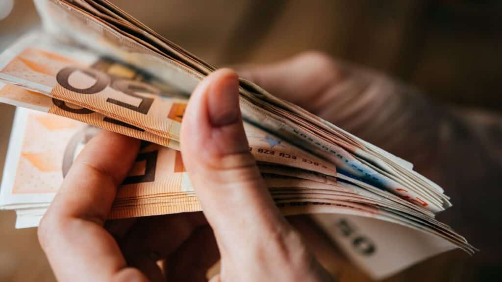 Main tenant des billets d'euros.