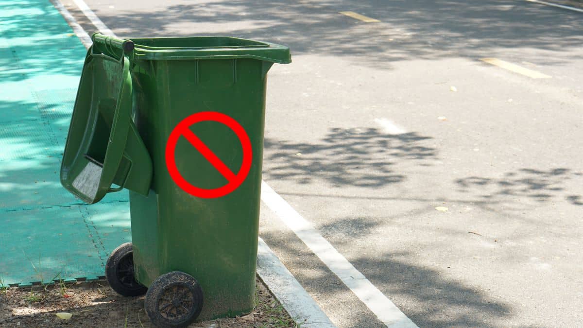 Poubelle verte avec logo interdit rouge.
