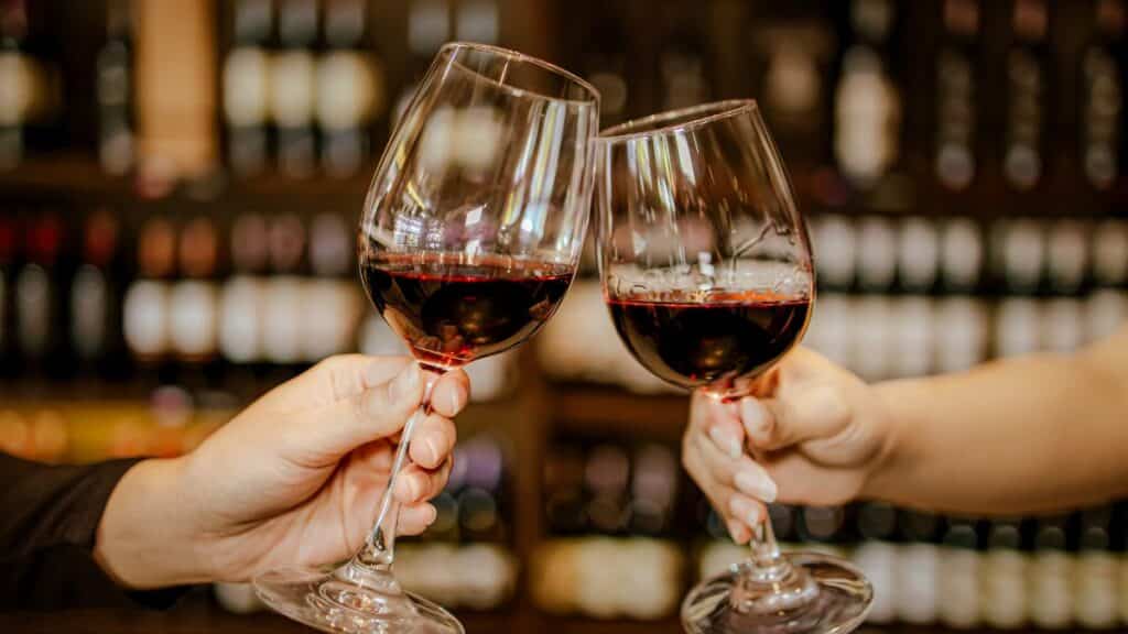 Deux verres de vin rouge trinquent.