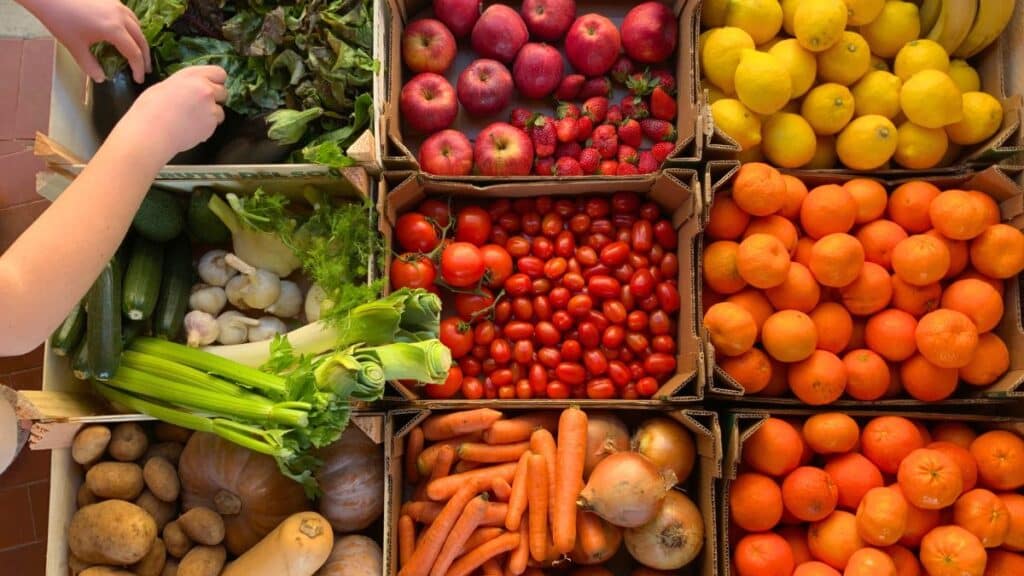 Assortiment de fruits et légumes frais en caisses.