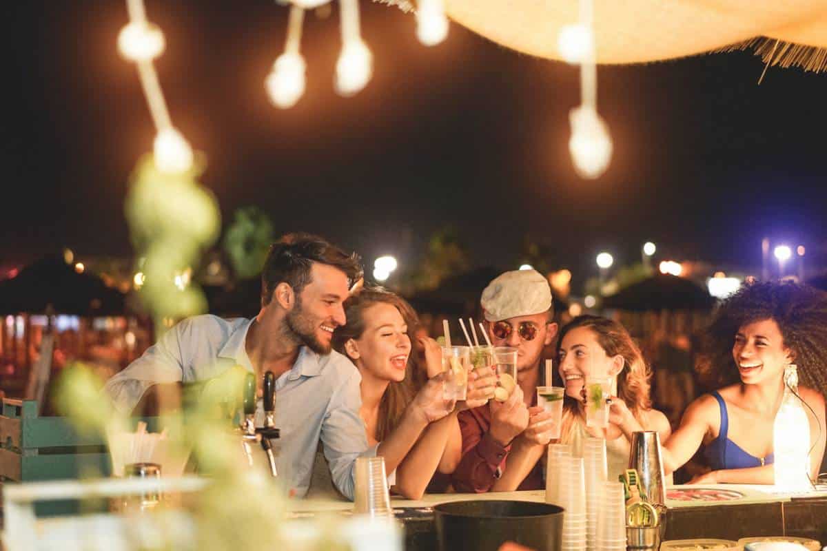 Groupe d'amis trinquant au bar de nuit.