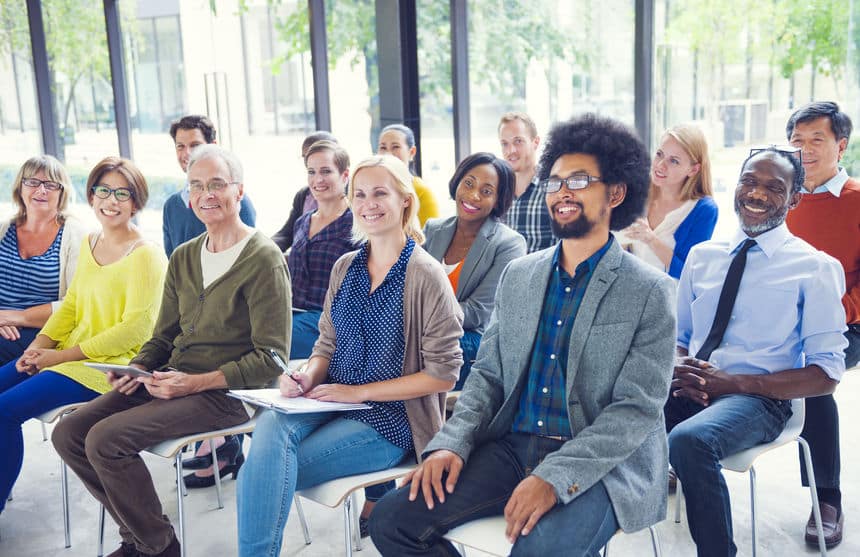 Groupe de personnes assises souriantes.