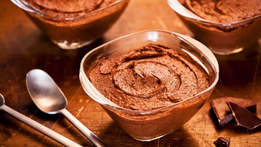Desserts de mousse au chocolat sur table en bois.