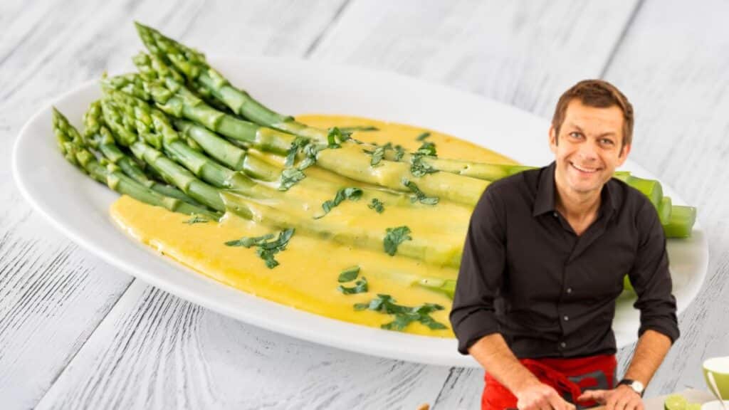 Asperges sauce jaune sur assiette, homme souriant devant.