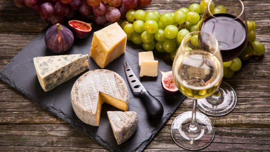 Assortiment de fromages et vins avec fruits.