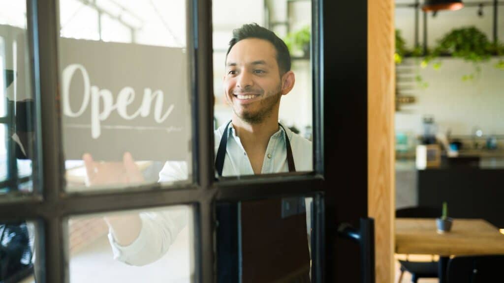 Homme souriant ouvrant sa boutique.