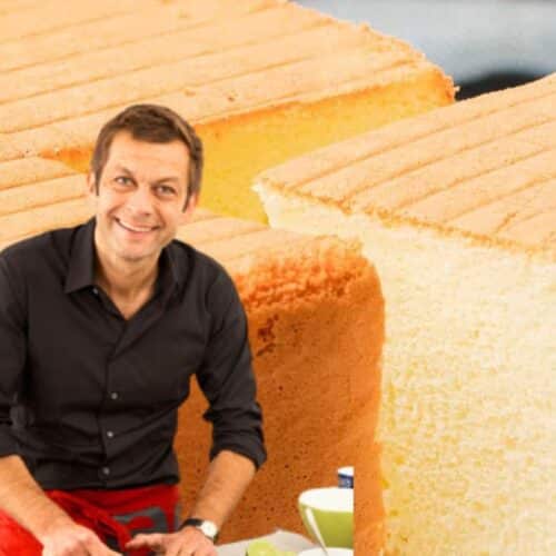 Homme souriant devant un gâteau coupé.