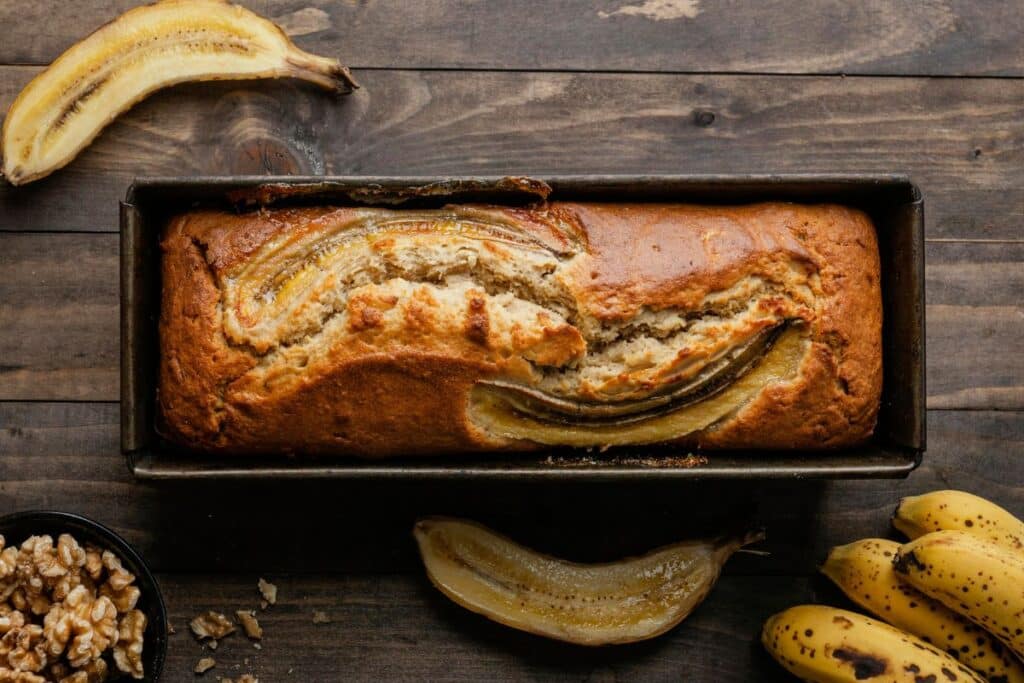 Pain aux bananes et noix sur table en bois.