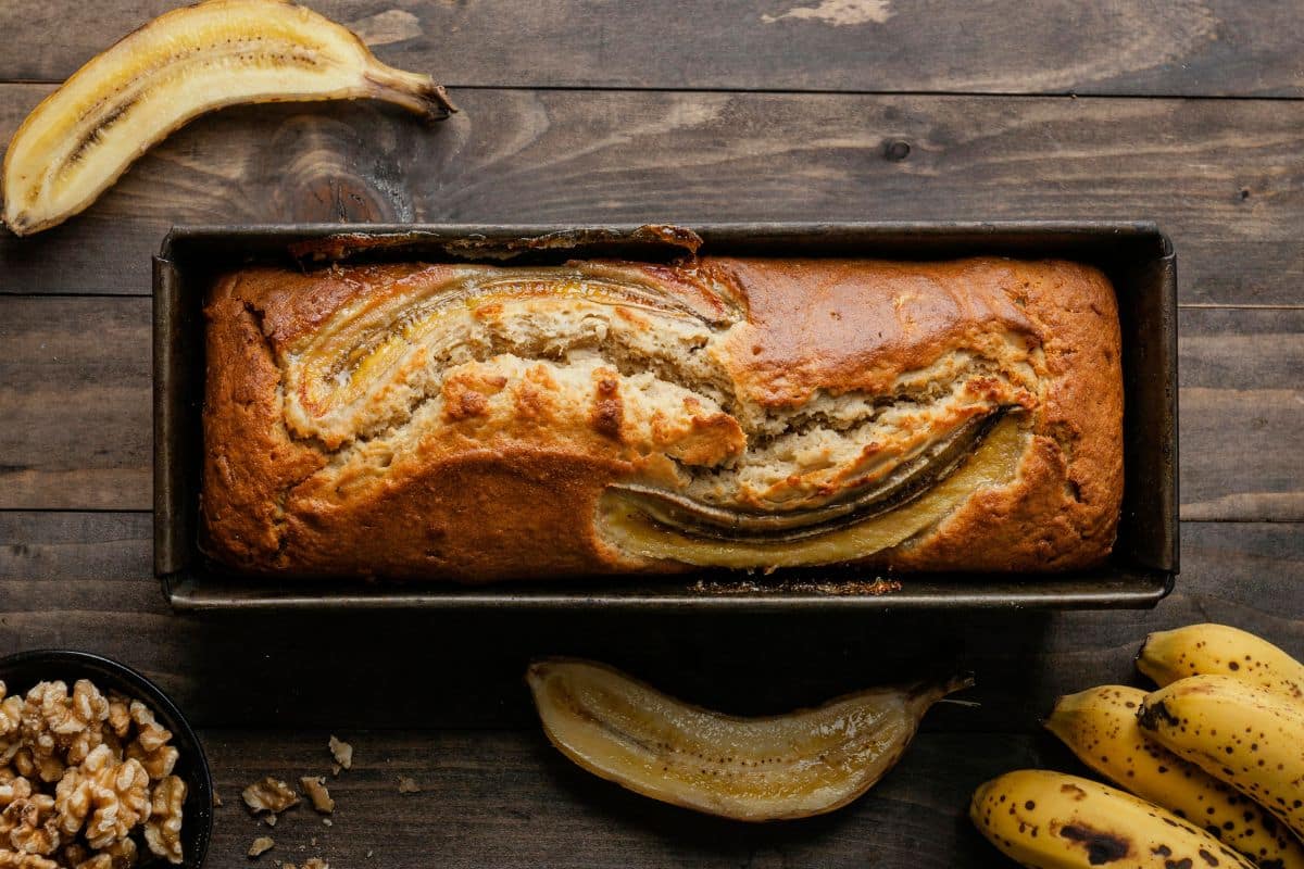 Pain aux bananes et noix sur table en bois.