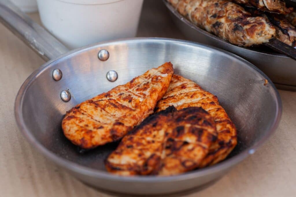 Poulet grillé dans une poêle en métal.
