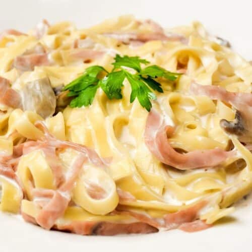 Tagliatelles au jambon, sauce crémeuse et persil.